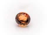 an orange sapphire stone on a white background