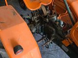 two orange lawn mowers sitting in a garage