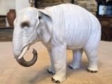 statue of an elephant on a table with a fireplace in the background