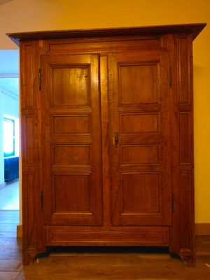 une grande armoire en bois dans le coin d'une pièce