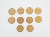 a close up of a bunch of gold coins on a white surface