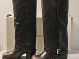 pair of brown boots sitting on top of a white table next to a box