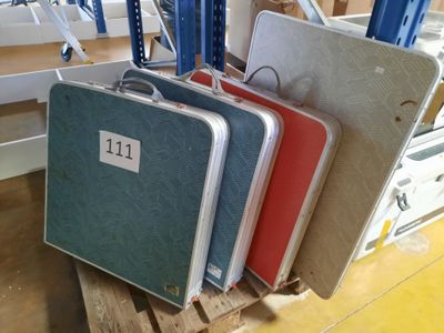 Plusieurs bagages sont empilés sur une palette dans un entrepôt