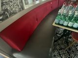 une photo d'un restaurant avec une banquette rouge et noire