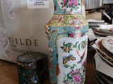 un grand vase posé sur un comptoir, à côté d'une pile d'assiettes