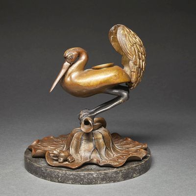 sculpture of a pelican sitting on a leaf on a base