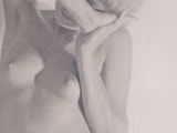 an old photo of a nude woman with her hands on her head