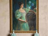 un tableau représentant une femme en robe verte accroché au mur