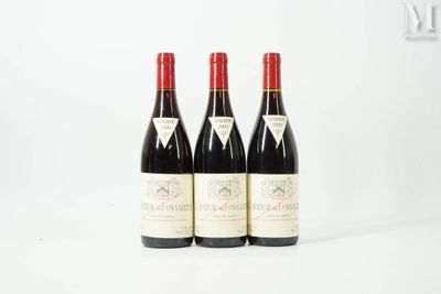 three bottles of red wine sitting on top of a white table
