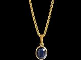 un collier en or avec une pierre bleue sur une chaîne