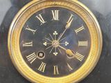a gold clock with roman numerals on the face