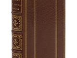 un livre en cuir marron avec des finitions dorées et une bordure dorée