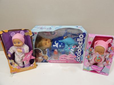 three dolls that are sitting next to each other on a table