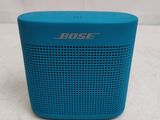 a blue bose bluetooth speaker sitting on top of a table