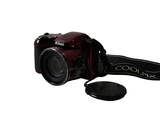 a red digital camera with a black strap on it