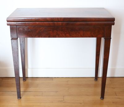 a small table with a wooden top on a hard wood floor