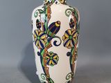 un vase blanc orné d'un motif bleu et jaune