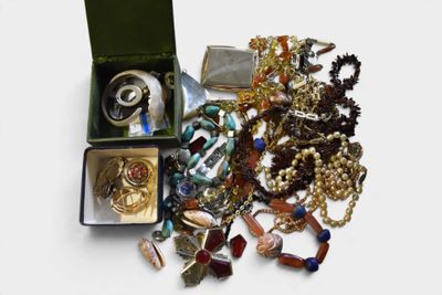 a box full of assorted jewelry on a white surface