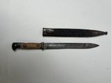 two knives sitting on top of a white table next to each other