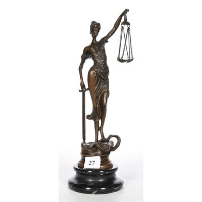 a bronze statue of a lady holding a sword and a scale