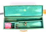 a green case with a pair of scissors inside of it