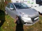 a small silver car parked in the grass next to a white van