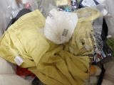 a pile of clothes in a plastic bag on a bed