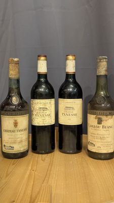 quatre bouteilles de vin sont alignées sur une table en bois
