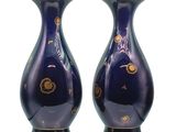 une paire de vases bleus ornés de motifs dorés sur fond blanc
