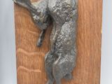 two sculptures of a dog and a cat on a wooden plaque