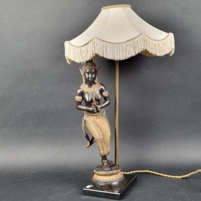 a lamp that has a woman holding a lamp shade on it