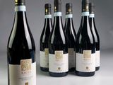 six bottles of wine are lined up in a row on a table