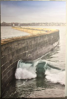 une grande photo d'un homme surfant sur une vague avec sa planche de surf