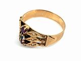 a close up of a gold ring with a purple stone