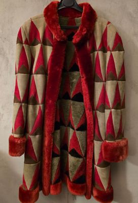 une photo d'un manteau rouge et beige accroché au mur