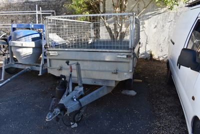 un camion blanc attelé à une remorque, garé sur un parking