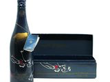the bottle of wine is next to a box of chocolates