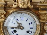 a gold clock with roman numerals on the face