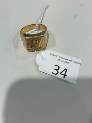 une bague en or posée sur une table blanche, avec une étiquette de prix