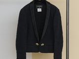 the jacket is hanging on a clothes rack next to a wall