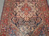 Un tapis persan ancien est posé sur le sol dans une pièce.