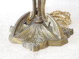 a gold colored table lamp with a rope on it
