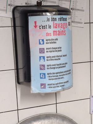 a sign hanging on the wall of a public restroom