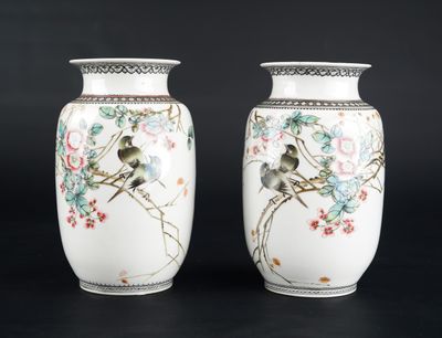 deux vases blancs ornés d'oiseaux et de fleurs sur fond noir
