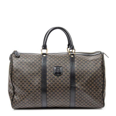 a brown and black duffel bag sitting on top of a white surface