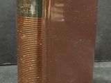an old book sitting on top of a table next to a gray wall