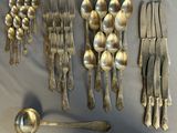 a lot of silver spoons and forks on the table
