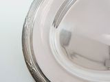 a silver plate on a white table with a white background