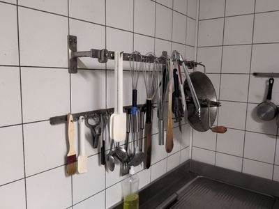 a kitchen with a lot of utensils hanging on the wall
