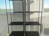 two black shelves in the corner of a room